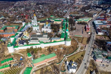 Sergiev Posad 'daki Trinity-Sergius Lavra' nın altın kulelerinin panoramik görüntüsü ve antik mimari çözümleri. Güneşli bir bahar gününde insansız hava aracından çekildi. 