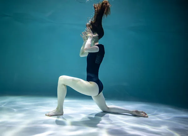 Piękna Dziewczyna Czarny Trykot Robi Gimnastyczne Ćwiczenia Pod Wodą Niebieskim — Zdjęcie stockowe
