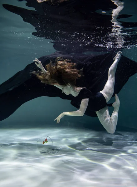 수영복을 오를입은 아름다운 소녀가물 배경에 수족관에서 물고기와 — 스톡 사진