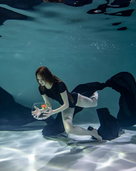 수영복을 오를입은 아름다운 소녀가물 배경에 수족관에서 물고기와 — 스톡 사진