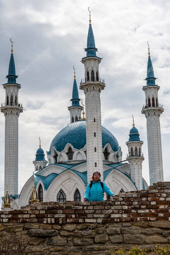 woman tourist in a blue jacket exploring the sights of the old Kremlin in Kazan