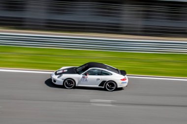 Yarış arabaları pistteki yarışlarda yüksek hızda yol alır.