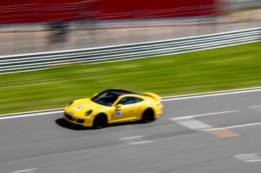 Yarış arabaları pistteki yarışlarda yüksek hızda yol alır.