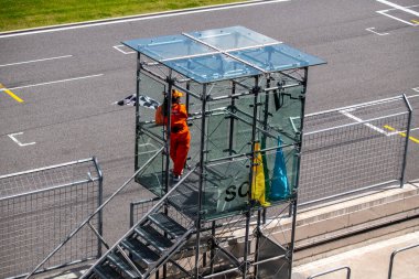 Pistteki spor araba yarışlarında güvenliği izleyen yarış pisti personeli.