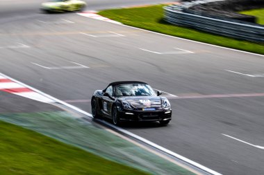 Yarış arabaları pistteki yarışlarda yüksek hızda yol alır.