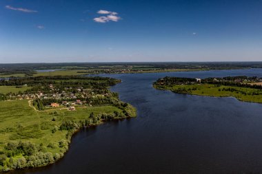 İHA 'dan geniş bir göl, orman, tarla ve yolların köyüne panoramik manzara 