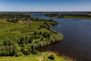 İHA 'dan geniş bir göl, orman, tarla ve yolların köyüne panoramik manzara 