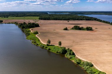 İHA 'dan geniş bir göl, orman, tarla ve yolların köyüne panoramik manzara 