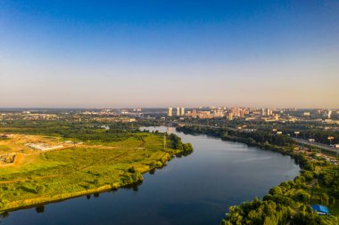 Bir göl kenarındaki yerleşim yerinin panoramik görüntüsü ve metropolün dışındaki bir orman insansız hava aracı tarafından filme alındı. 