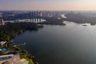 Bir göl kenarındaki yerleşim yerinin panoramik görüntüsü ve metropolün dışındaki bir orman insansız hava aracı tarafından filme alındı. 