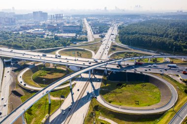 Sabahın erken saatlerinde insansız hava aracının yüksekliğinden yeşil ormanlar ve yollar arasındaki zarif kavşak. 