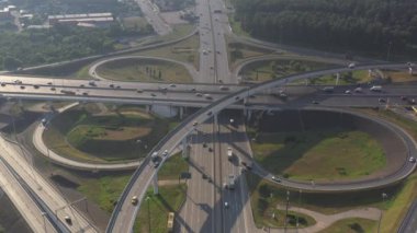 Sabahın erken saatlerinde insansız hava aracının yüksekliğinden yeşil ormanlar ve yollar arasındaki zarif kavşak.