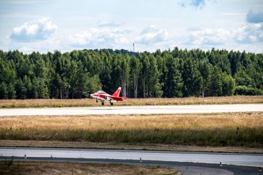 combat red aircraft makes difficult turns in the air against the background of the sky