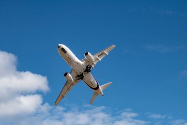 a white passenger plane makes sharp turns near the airfield