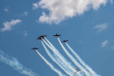 beautiful plane makes a difficult turn leaves a white trail of flight against the background of the sky