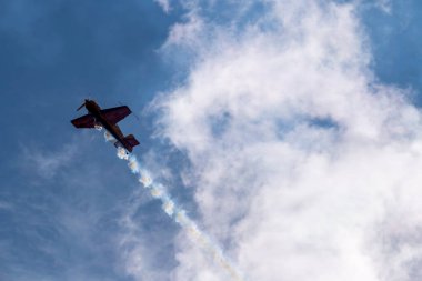 beautiful plane makes a difficult turn leaves a white trail of flight against the background of the sky