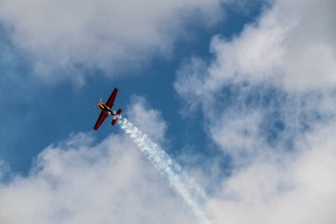 beautiful plane makes a difficult turn leaves a white trail of flight against the background of the sky