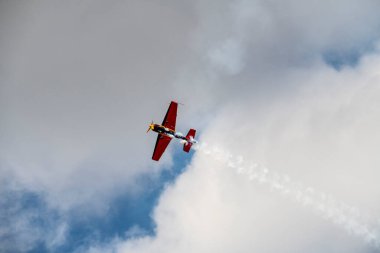 beautiful plane makes a difficult turn leaves a white trail of flight against the background of the sky