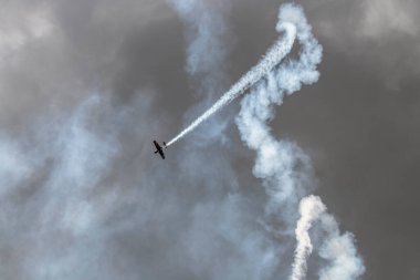 beautiful plane makes a difficult turn leaves a white trail of flight against the background of the sky