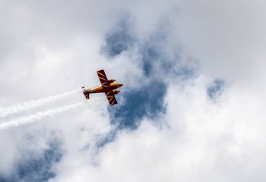 beautiful plane makes a difficult turn leaves a white trail of flight against the background of the sky