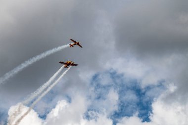 beautiful plane makes a difficult turn leaves a white trail of flight against the background of the sky
