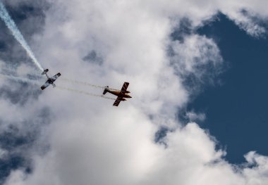 beautiful plane makes a difficult turn leaves a white trail of flight against the background of the sky