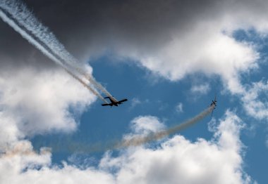 beautiful plane makes a difficult turn leaves a white trail of flight against the background of the sky