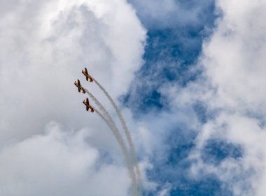 beautiful plane makes a difficult turn leaves a white trail of flight against the background of the sky