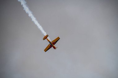 beautiful plane makes a difficult turn leaves a white trail of flight against the background of the sky