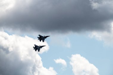 combat aircraft makes difficult turns in the air against the background of the sky 