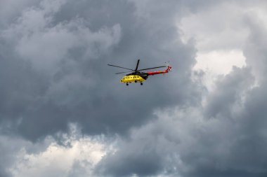 helicopters blow out a stream of smoke and make complex figures in flight against the background of the sky