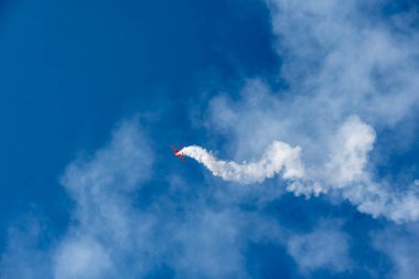 24 Temmuz 2021 'de Zhukovsky' deki Max-21 havacılık salonunda kırmızı uçak zor dönüşler yapıyor ve mavi gökyüzüne beyaz duman üflüyor.