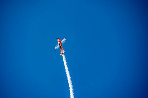 Red Plane Makes Difficult Turns Blows White Smoke Blue Sky — Stock Photo, Image