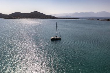 Spinalonga adasının panoramik görüntüsü. Gemiler ve turkuaz deniz insansız hava aracından çekiliyor. 