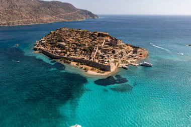 Spinalonga adasının panoramik görüntüsü. Gemiler ve turkuaz deniz insansız hava aracından çekiliyor. 
