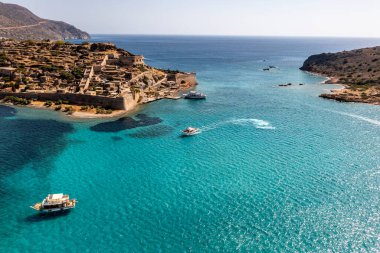 Spinalonga adasının panoramik görüntüsü. Gemiler ve turkuaz deniz insansız hava aracından çekiliyor. 