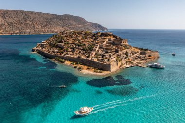 Spinalonga adasının panoramik görüntüsü. Gemiler ve turkuaz deniz insansız hava aracından çekiliyor. 