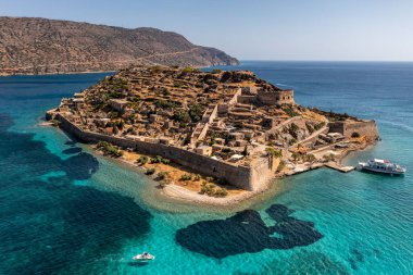 Spinalonga adasının panoramik görüntüsü. Gemiler ve turkuaz deniz insansız hava aracından çekiliyor. 