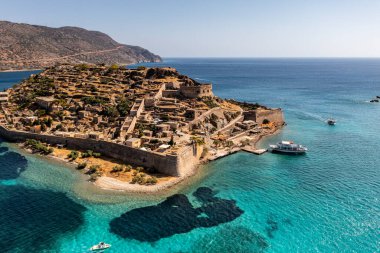 Spinalonga adasının panoramik görüntüsü. Gemiler ve turkuaz deniz insansız hava aracından çekiliyor. 