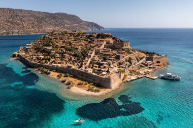 Spinalonga adasının panoramik görüntüsü. Gemiler ve turkuaz deniz insansız hava aracından çekiliyor. 
