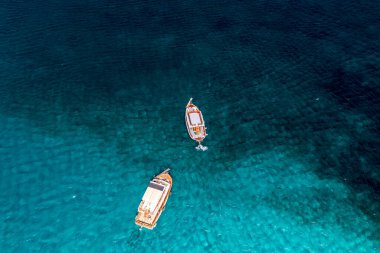 Spinalonga adasının panoramik görüntüsü. Gemiler ve turkuaz deniz insansız hava aracından çekiliyor. 