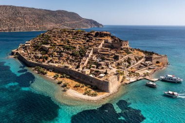 Spinalonga adasının panoramik görüntüsü. Gemiler ve turkuaz deniz insansız hava aracından çekiliyor. 