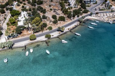 Deniz ve dağların panoramik görüntüsü ve bir drondan çekilen turkuaz su üzerindeki gemiler.