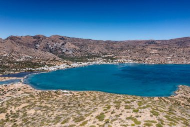 Deniz ve dağların panoramik görüntüsü ve bir drondan çekilen turkuaz su üzerindeki gemiler.