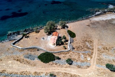 Deniz ve dağların panoramik görüntüsü ve bir drondan çekilen turkuaz su üzerindeki gemiler.
