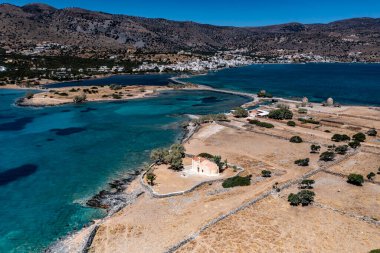 Deniz ve dağların panoramik görüntüsü ve bir drondan çekilen turkuaz su üzerindeki gemiler.