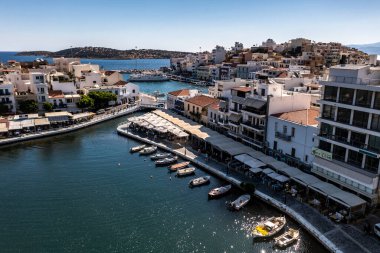 Deniz ve dağların panoramik görüntüsü ve bir drondan çekilen turkuaz su üzerindeki gemiler.