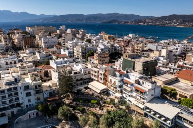Deniz ve dağların panoramik görüntüsü ve bir drondan çekilen turkuaz su üzerindeki gemiler.