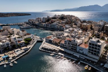 Deniz ve dağların panoramik görüntüsü ve bir drondan çekilen turkuaz su üzerindeki gemiler.