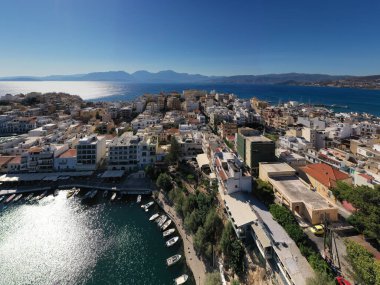 Deniz ve dağların panoramik görüntüsü ve bir drondan çekilen turkuaz su üzerindeki gemiler.